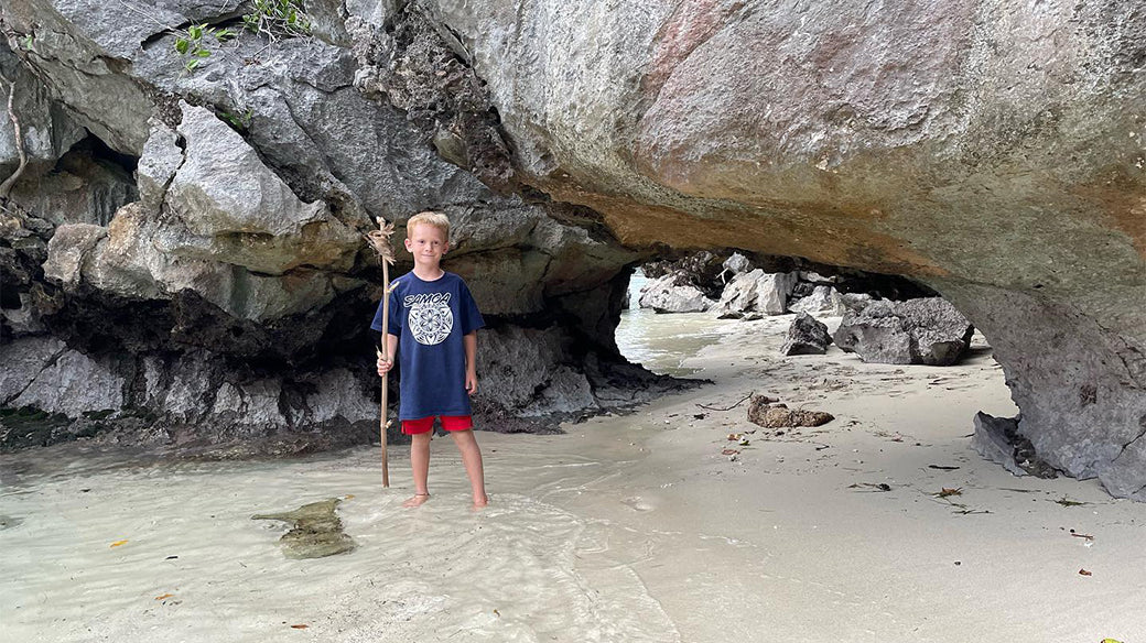 Boy spearfishing near the pacific ocean with a captured crab