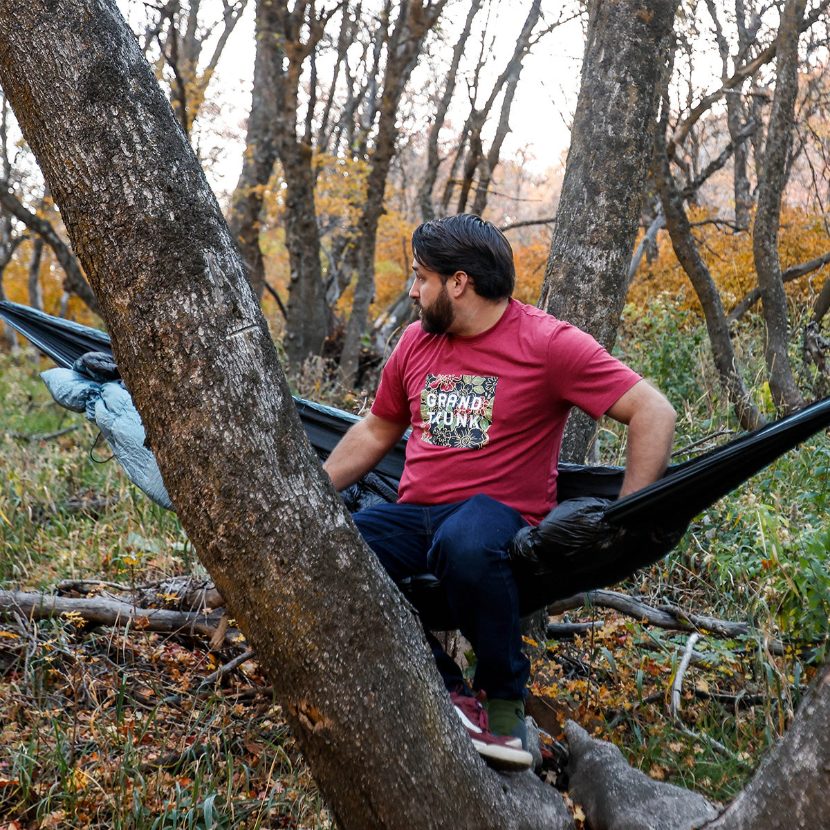 man sits in evolution sleeping bag hammock