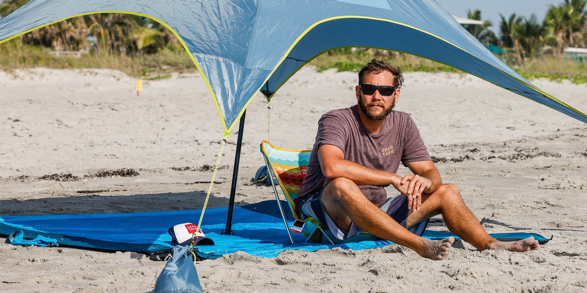 man sitting on mayfly chair on parasheet beach blanket under shadecaster 2