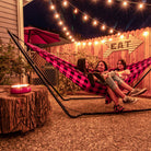 3 ladies enjoy the Grand Trunk Hammock Stand backyard hangout patio lights