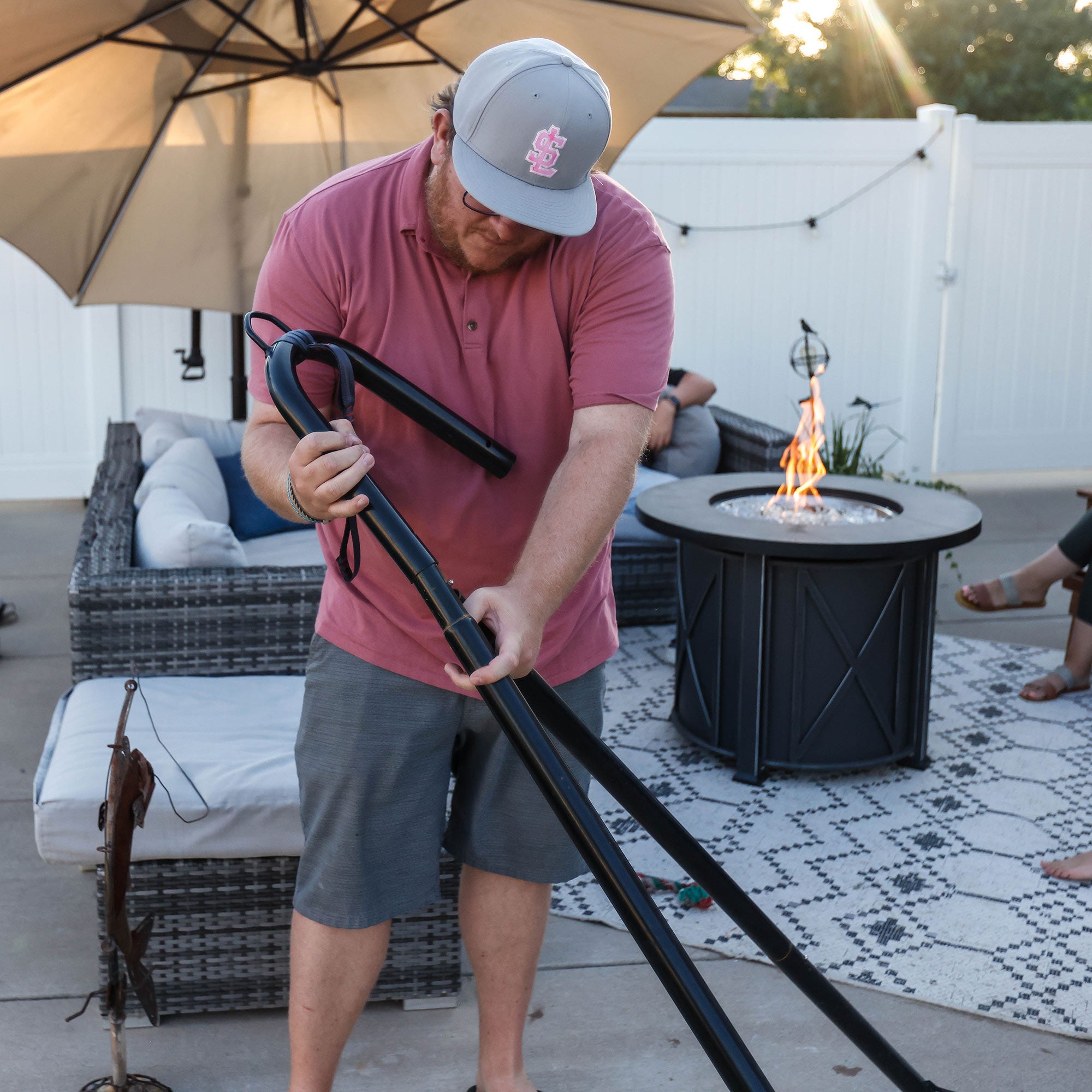 Man putting together Grand Trunk Hammock Stand backyard hangout patio deck