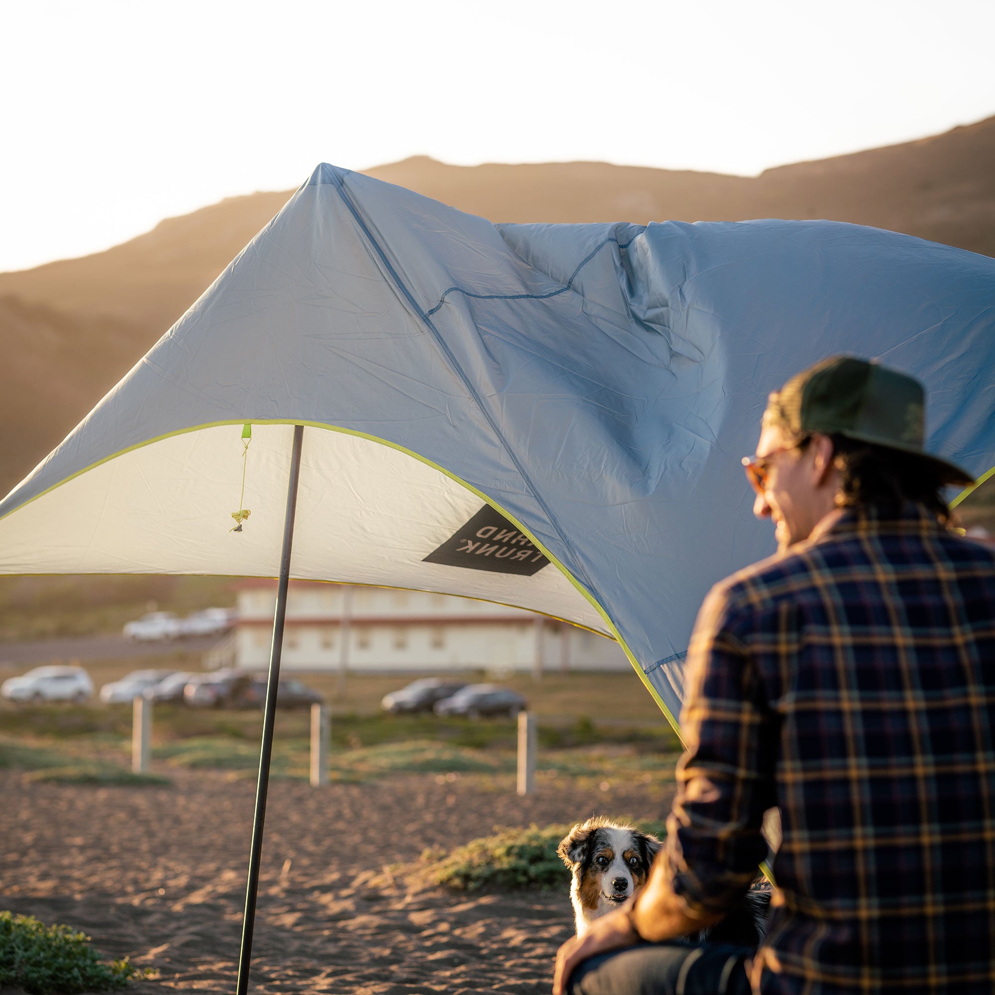shadecaster 4 with dog and man in a mountain valley sunset on the beach