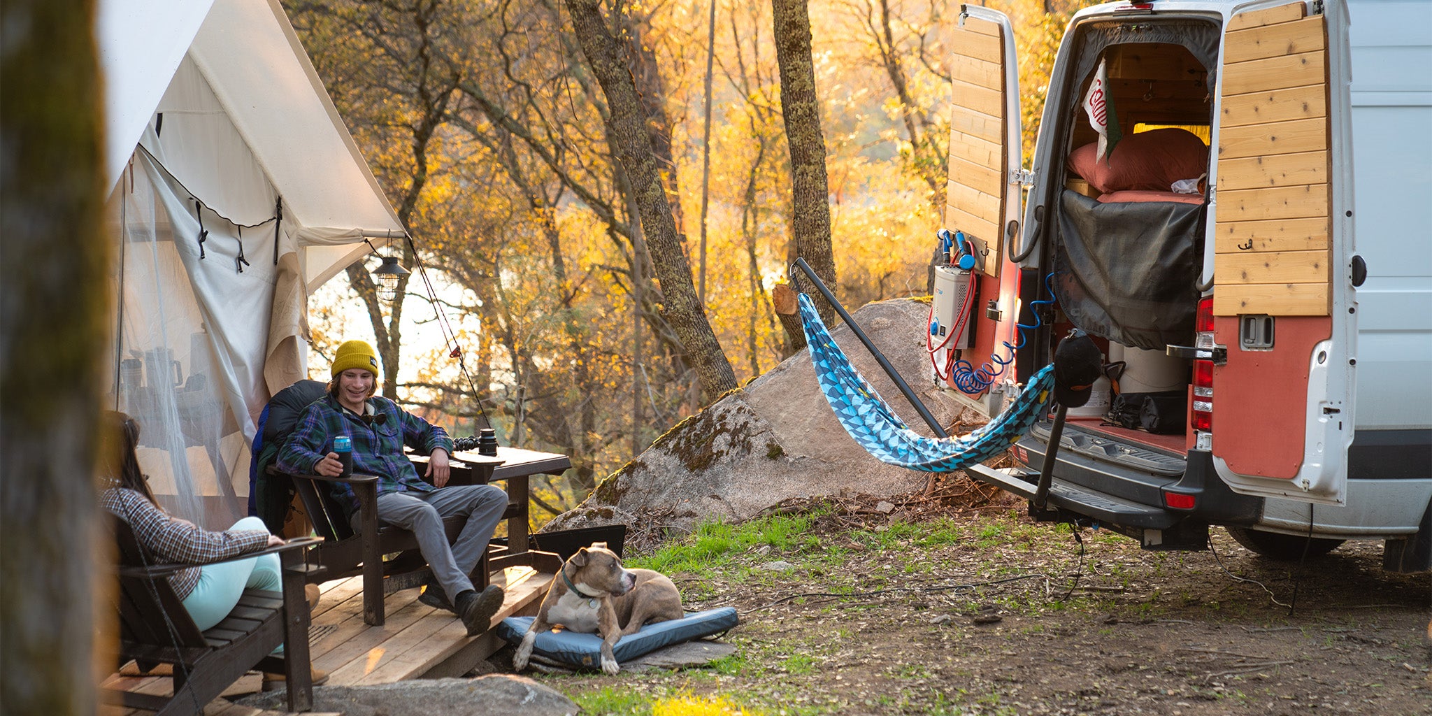 man and dog sit outside a little cabin with a van hitch hammock stand flowcheck TrunkTech™ hammock