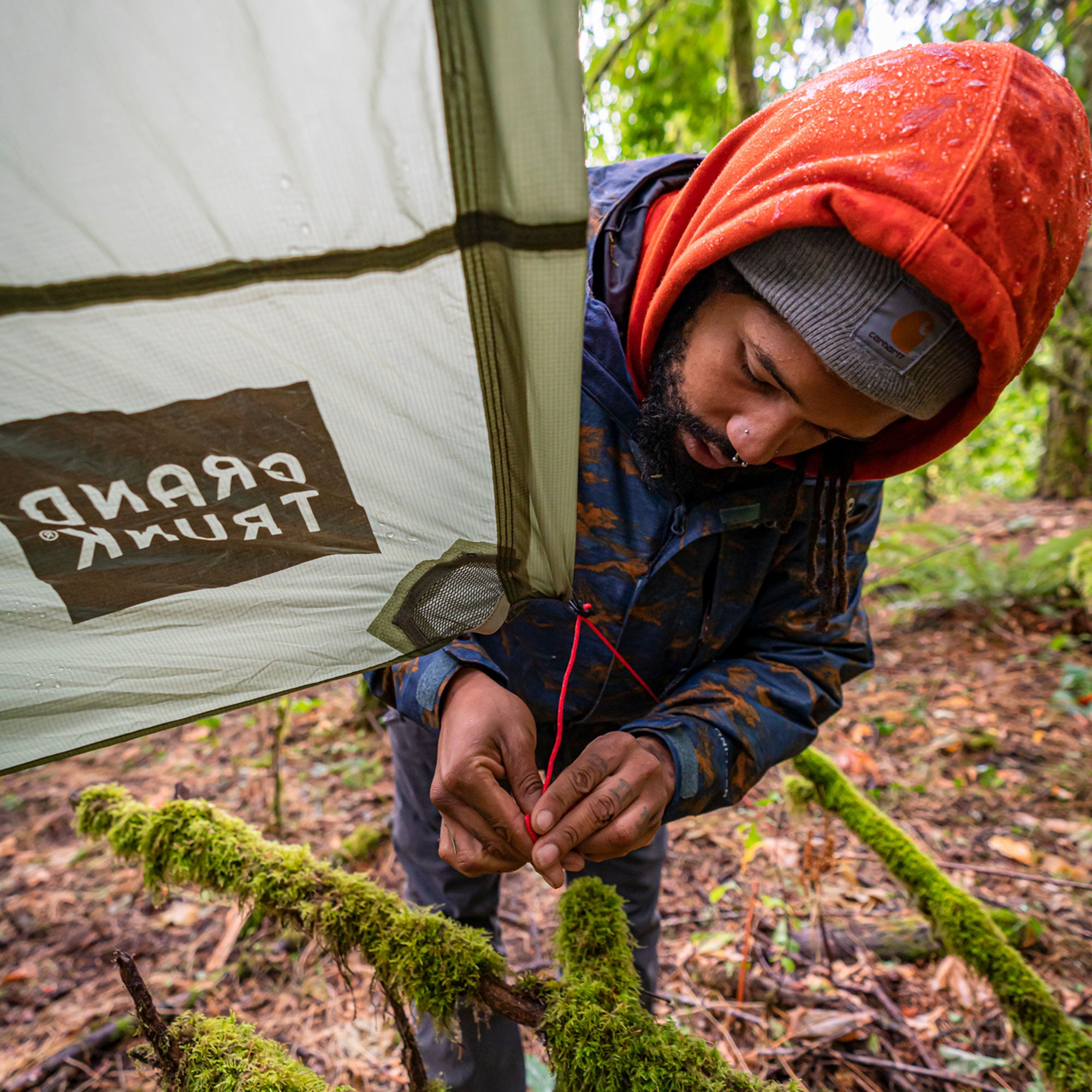 man sets up the moab with some mossy branches