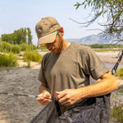 man setting up the skeeter beeter hammock in a swampy outdoor area