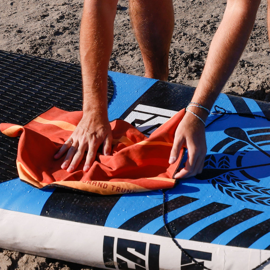 cleaning SUP paddle board with microfiber towel