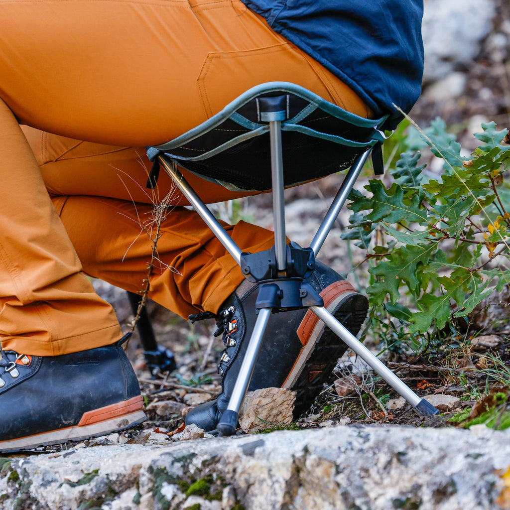 Compass 360° Stool closeup outdoors with man seated wearing ridgemont footwear