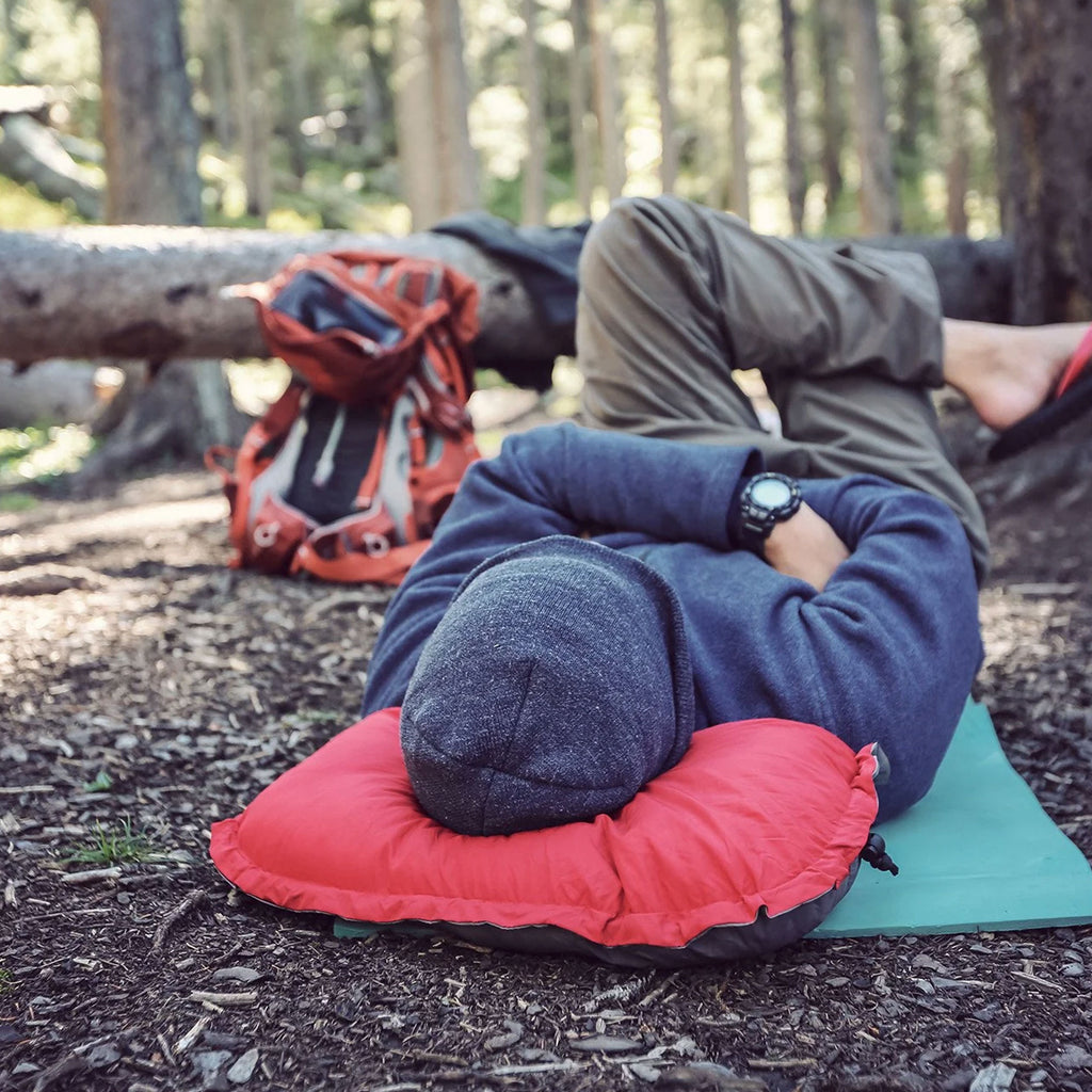 travel pillow on a man's camp mat pad in the dirt outdoors in forest