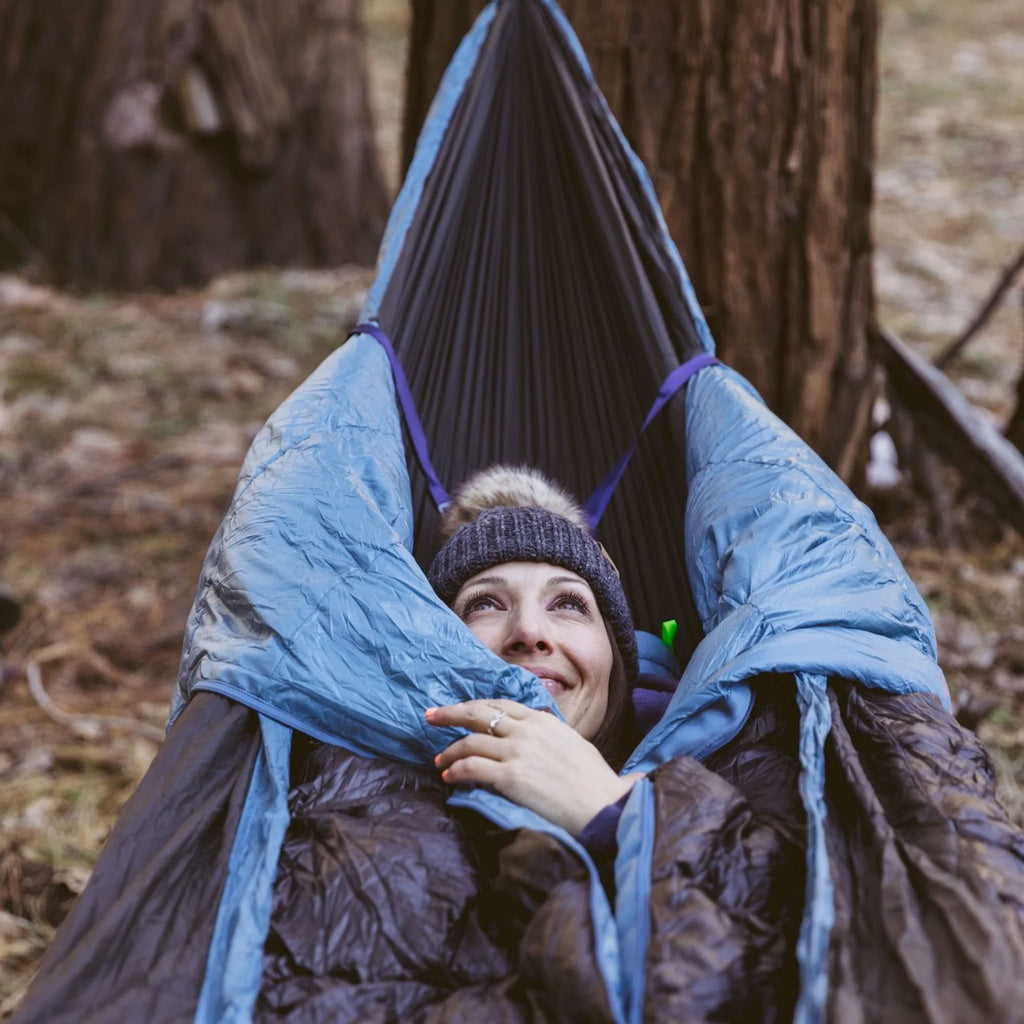Woman smiling in Evolution Hammock comfortable and cozy hammock camping in forest outdoors