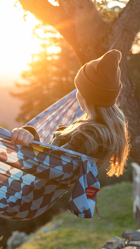woman sits in flowcheck trunktech™ hammock sunset