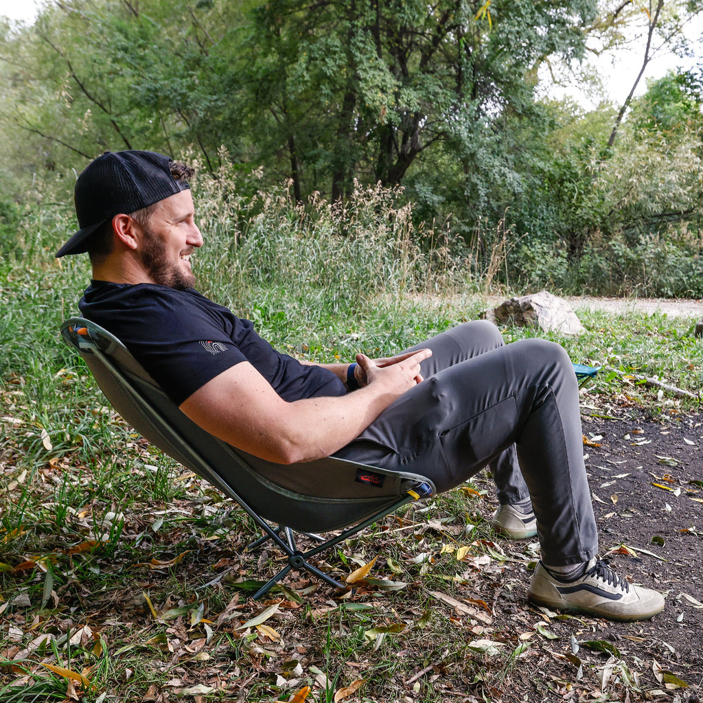Man relaxing at campground in mantis chair around firepit