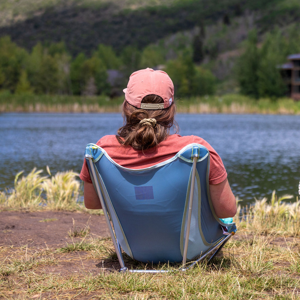Woman sitting in Grand Trunk Mayfly Chair by lake