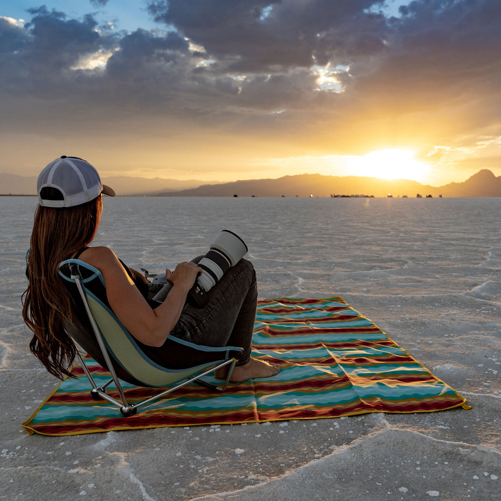 Female photoographer sitting on Meadow Mat enjoy a scenic view on salt flats